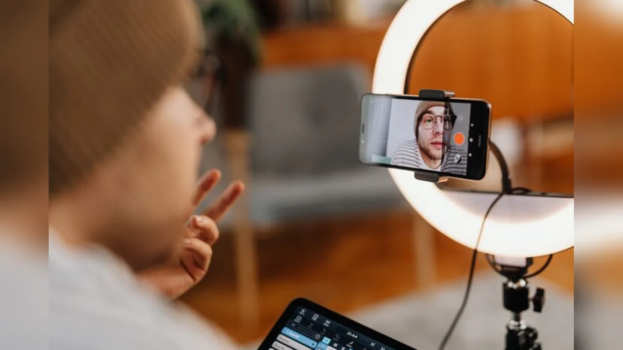 A creator recording a video on a phone with a ring light in a home studio