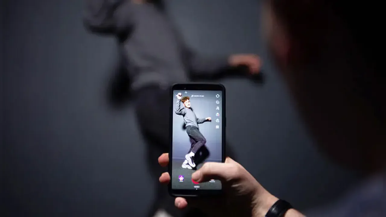 A creator filming a short dance video on a phone indoors